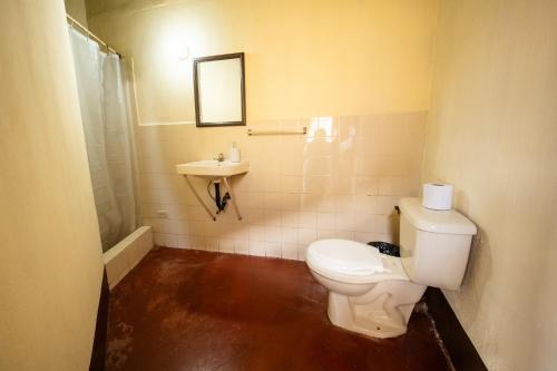 a bathroom with a toilet and a sink at Hotel Itzel in Cobán