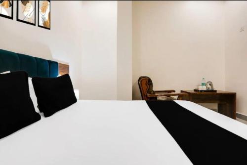 a white bed with black pillows in a bedroom at Hotel Agam-Railway Station Kota in Tīrath