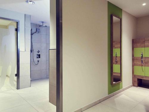 ein Badezimmer mit Dusche und Spiegel in der Unterkunft Mercure Tagungs- & Landhotel Krefeld in Krefeld