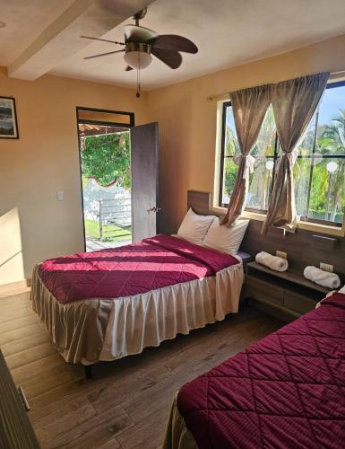 a bedroom with two beds and a ceiling fan at Habitaciones Casa Cuscatlan in Tamanique