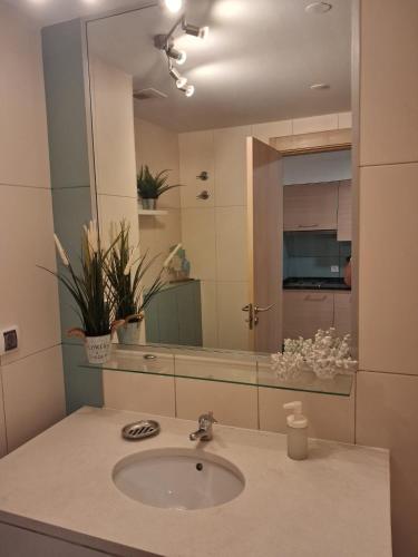 a bathroom with a sink and a large mirror at Vila Verde Sal Calistemon in Prainha