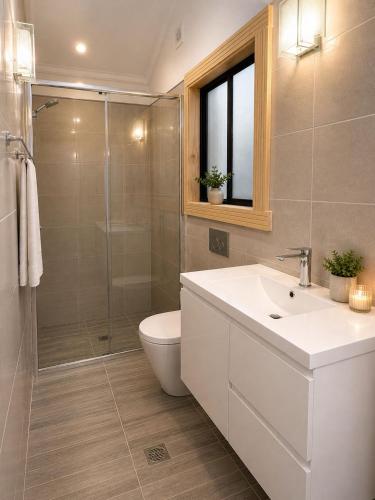 a bathroom with a toilet and a sink and a shower at Cosy Studio- Blue Mountains in Wentworth Falls