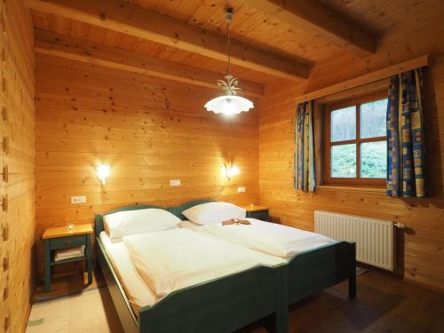 ein Schlafzimmer mit einem Bett in einem Holzzimmer in der Unterkunft Haus Helene im Öko-Feriendorf in Schlierbach