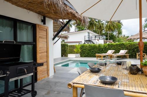 a patio with a table with a grill and a pool at Manao Pool Villa 9 - 5 Mins Walk To The Beach in Ko Lanta