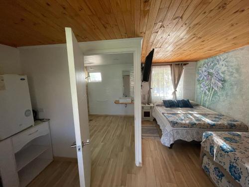 a bedroom with two beds and a wooden ceiling at Rancho Elquino in Vicuña