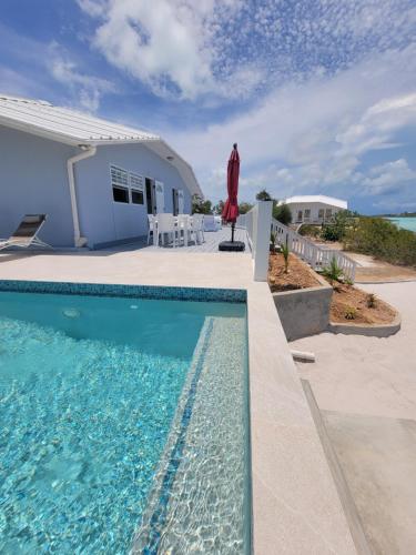 a swimming pool in front of a house at Swan cottages #6 Waterfront in Providenciales
