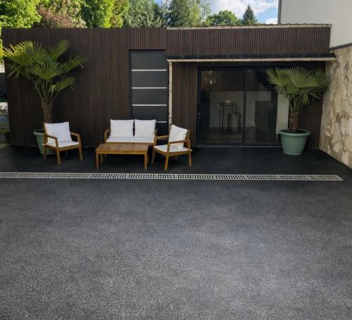 a house with a patio with two chairs and a building at Le Petit Cocon in Amiens