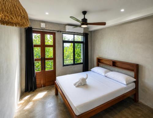 a bedroom with a bed and a ceiling fan at Hideout Siargao in General Luna