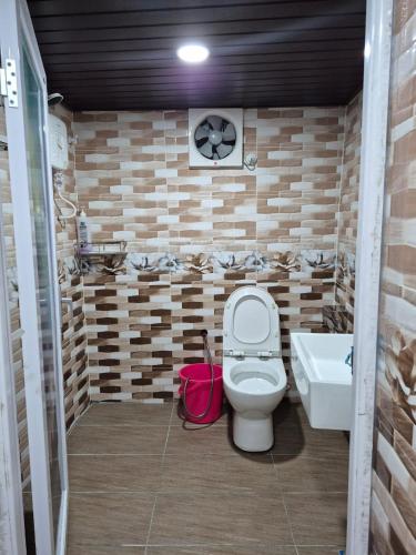 a bathroom with a toilet and a sink at Orchid Chalet in Ringlet