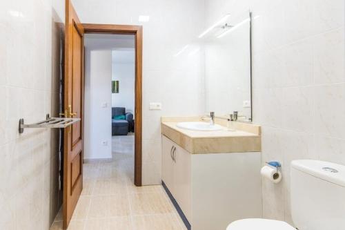 a bathroom with a toilet and a sink and a mirror at Apartamento Atenea in San Bartolomé