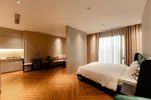 a bedroom with a bed and a desk and a kitchen at TQ Luxury Hotel & Apartment in An Khê