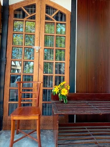 a wooden bench and a chair and a vase of flowers at SEE CHAIN Resort in Digana
