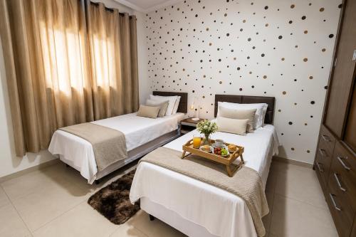 a bedroom with two beds with a tray of fruit on the bed at Flat 2 quartos em residencial | Ar e garagem in Ourinhos