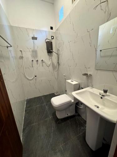 a bathroom with a toilet and a sink at Surf del mar in Arugam Bay