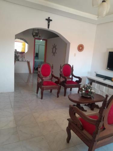 a living room with chairs and a table and a cross at Casa temporada in Lençóis
