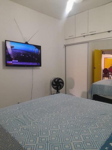 a bedroom with a bed with a flat screen tv on the wall at Casa temporada in Lençóis