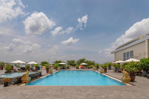 a pool at a resort with chairs and umbrellas at Hotel Cambodiana in Phnom Penh