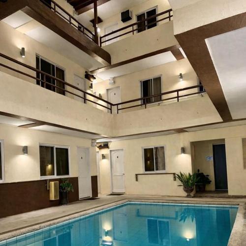 a large swimming pool in a building with a balcony at Iwayan Beach Resort in Panglao Island