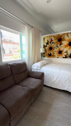 a living room with a couch and a bed at Bungalows Mufrance in San Patricio Melaque
