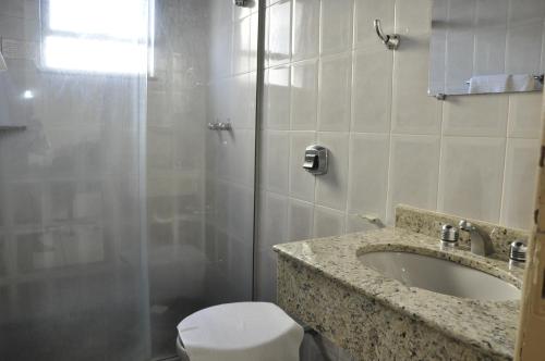 uma casa de banho com um chuveiro, um lavatório e um WC. em Imperial Hotel em Juiz de Fora