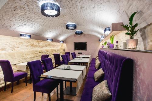 a dining room with purple chairs and tables at Hotel Natalia 18 in Lviv