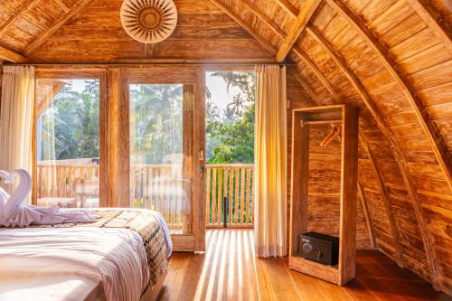 a bedroom with a large bed in a wooden house at Misane Serenity in Gianyar