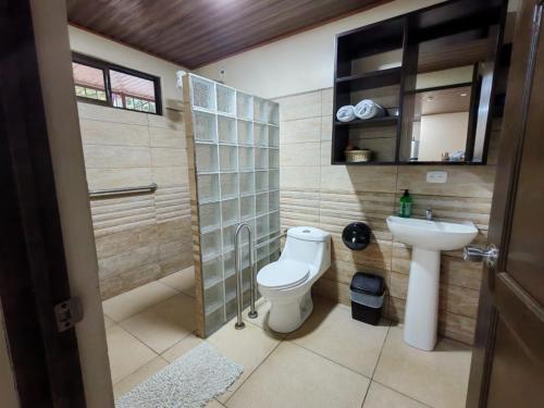 a bathroom with a toilet and a sink at Cabinas El Paso de Moisés in Uvita