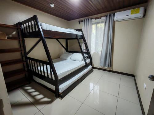 two bunk beds in a room with a window at Cabinas El Paso de Moisés in Uvita