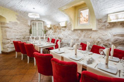 a restaurant with white tables and red chairs at Hotel Natalia 18 in Lviv
