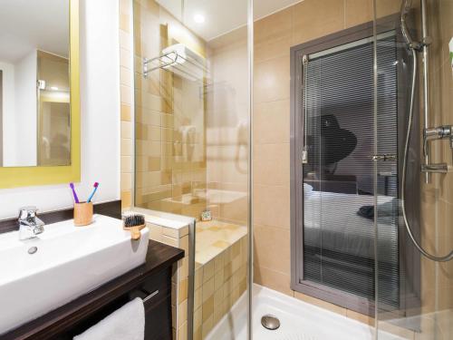 a bathroom with a sink and a shower with a glass door at ibis Styles Nice Vieux Port in Nice