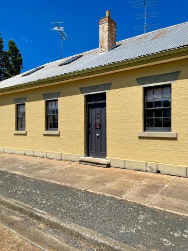 a yellow building with a door on a street at Whites Corner in Bothwell