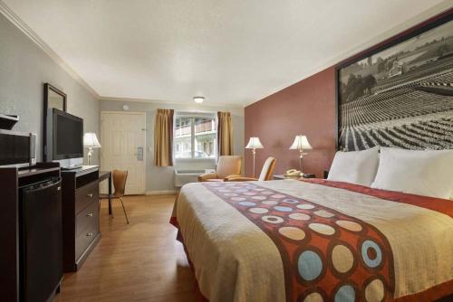 a hotel room with a bed and a flat screen tv at INN at King City in King City