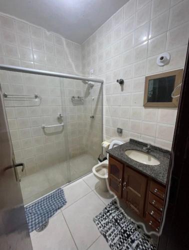 a bathroom with a shower and a sink and a toilet at Pousada Peruibe Praia Centro in Peruíbe