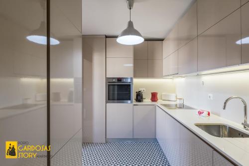 Cardosas Story Apartments by Porto City Hosts في بورتو: مطبخ أبيض مع حوض وميكروويف