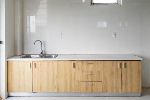 a kitchen with wooden cabinets and a sink at Khách sạn SIC Quảng Bình in Dong Hoi