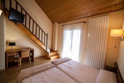 a bedroom with a large bed and a staircase at Hotel Avet in La Coma i la Pedra