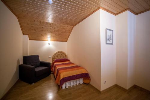 a bedroom with a bed and a chair in a room at Hotel Avet in La Coma i la Pedra