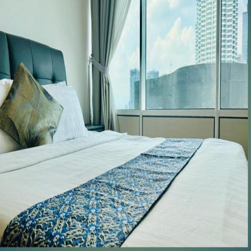 a bedroom with a bed with a large window at Sky klcc by DMK luxury suites Apartment in Kuala Lumpur