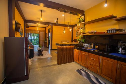 a kitchen with yellow walls and a black refrigerator at Cinnamon View Galle in Galle