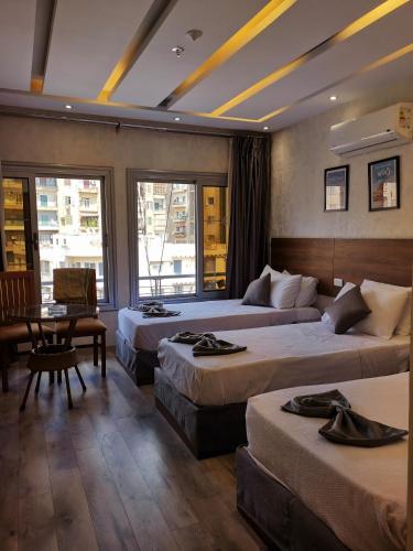 a hotel room with three beds and a table at tourist hotel cairo downtown in Cairo