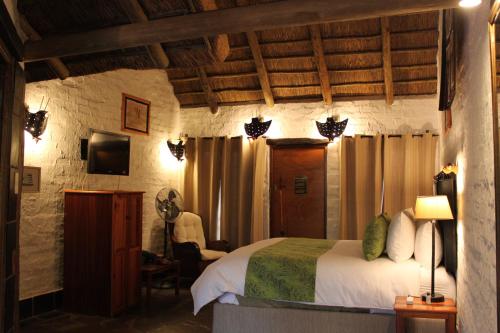 a bedroom with a bed and a tv in a room at Misty Hills Country Hotel, Conference Centre & Spa in Muldersdrift