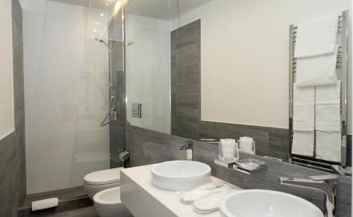 ローマにあるLHP Suite Roma Trastevereのバスルーム(洗面台2台、トイレ、鏡付)
