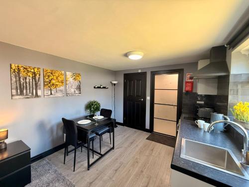 a kitchen and living room with a table and a sink at Leatherhead Studios by WorkStay in Leatherhead