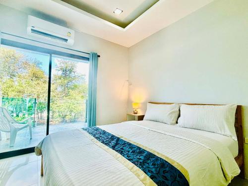 a bedroom with a bed and a large window at Emma in Ban Pak Khlong Phe