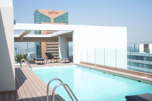 a swimming pool on the roof of a building at Loica Suites in Santiago