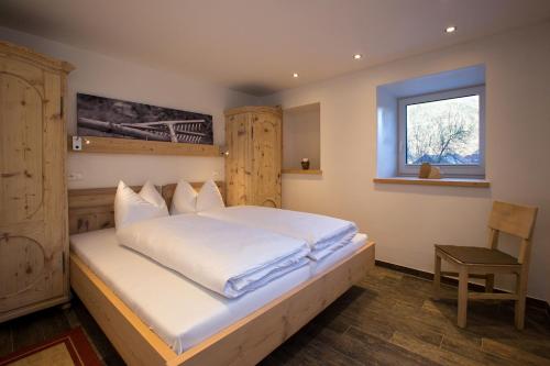 a bedroom with a large white bed with a window at Apart Lutz in Prutz