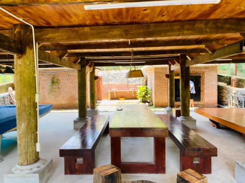 a patio with a table and benches and a fireplace at Homestay-pickleball in Ðồng Vo