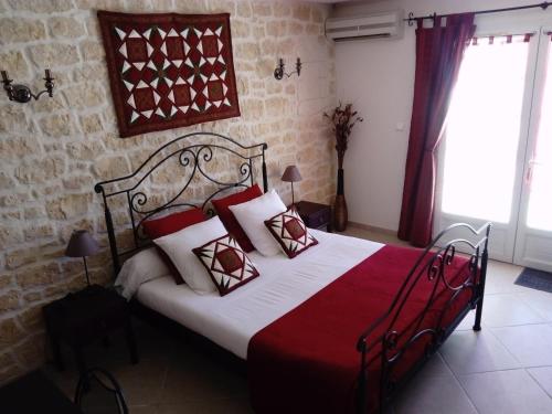 a bedroom with a bed with red and white pillows at Chez Isabelle et Guy B&B in Trans-en-Provence