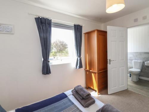 a bedroom with a bed and a window at Maes Y Coed in Pwllheli
