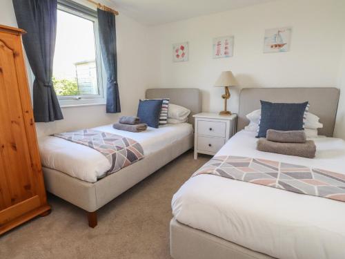 a bedroom with two beds and a window at Maes Y Coed in Pwllheli